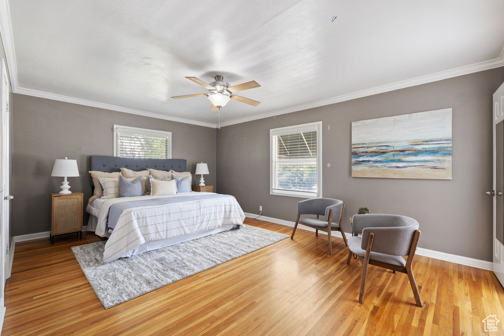 Bedroom featuring ceiling fan, crown molding, and light wood-type flooring