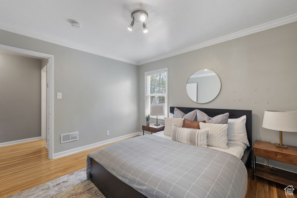 Bedroom featuring ornamental molding and hardwood / wood-style floors