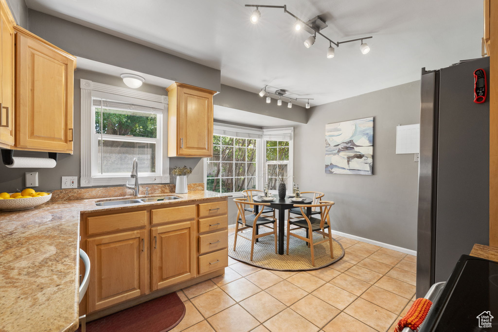 Kitchen featuring a wealth of natural light, track lighting, sink, and stainless steel refrigerator