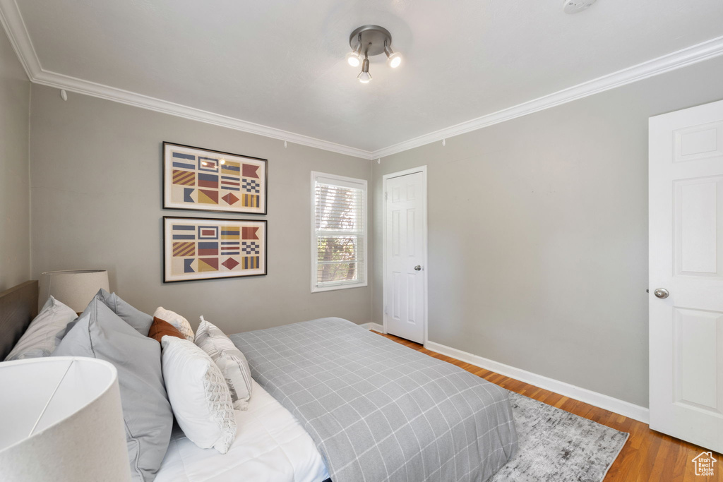 Bedroom featuring light hardwood / wood-style floors and crown molding