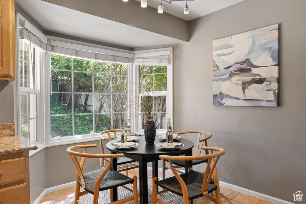 Dining area featuring track lighting and light tile flooring