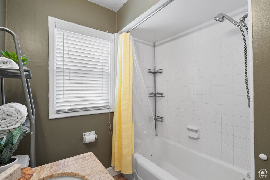 Full bathroom with shower / tub combo with curtain, a wealth of natural light, toilet, and vanity