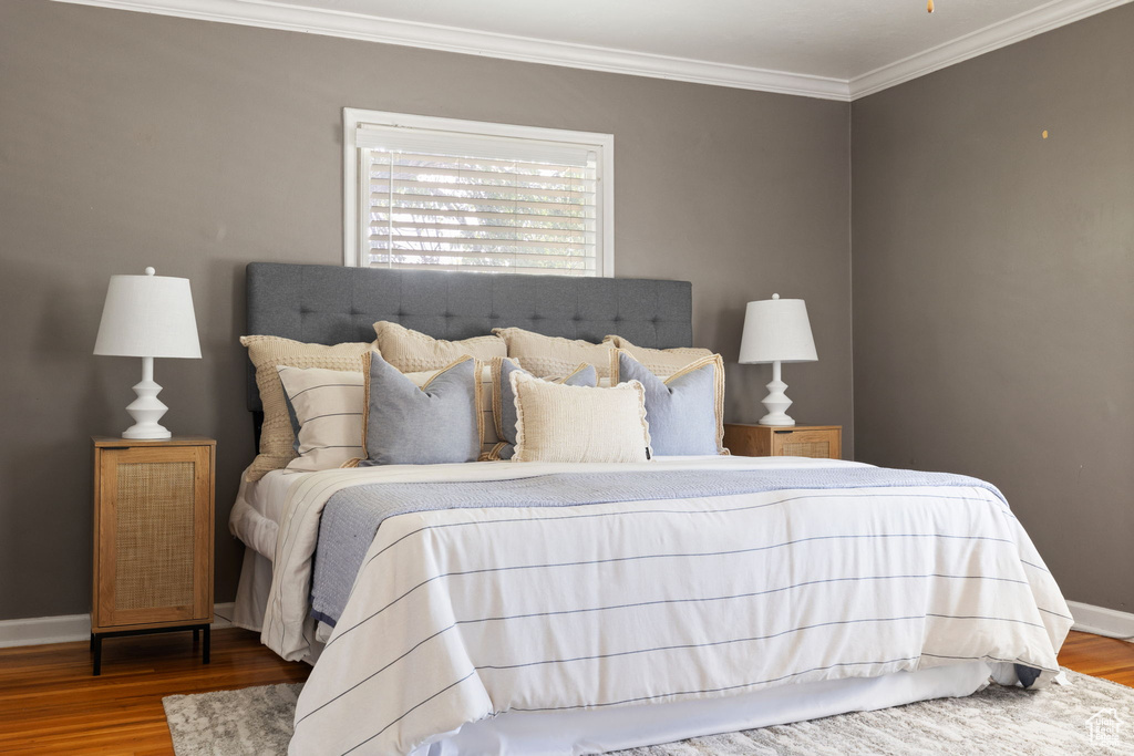 Bedroom featuring wood-type flooring and crown molding