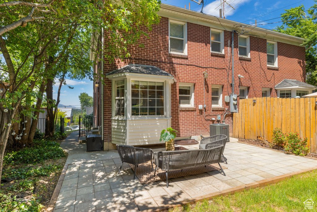 Rear view of house with a patio area and central AC