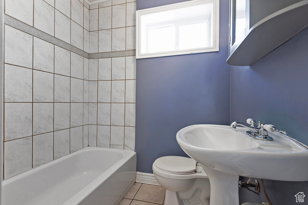 Bathroom with tiled shower / bath, tile flooring, and toilet