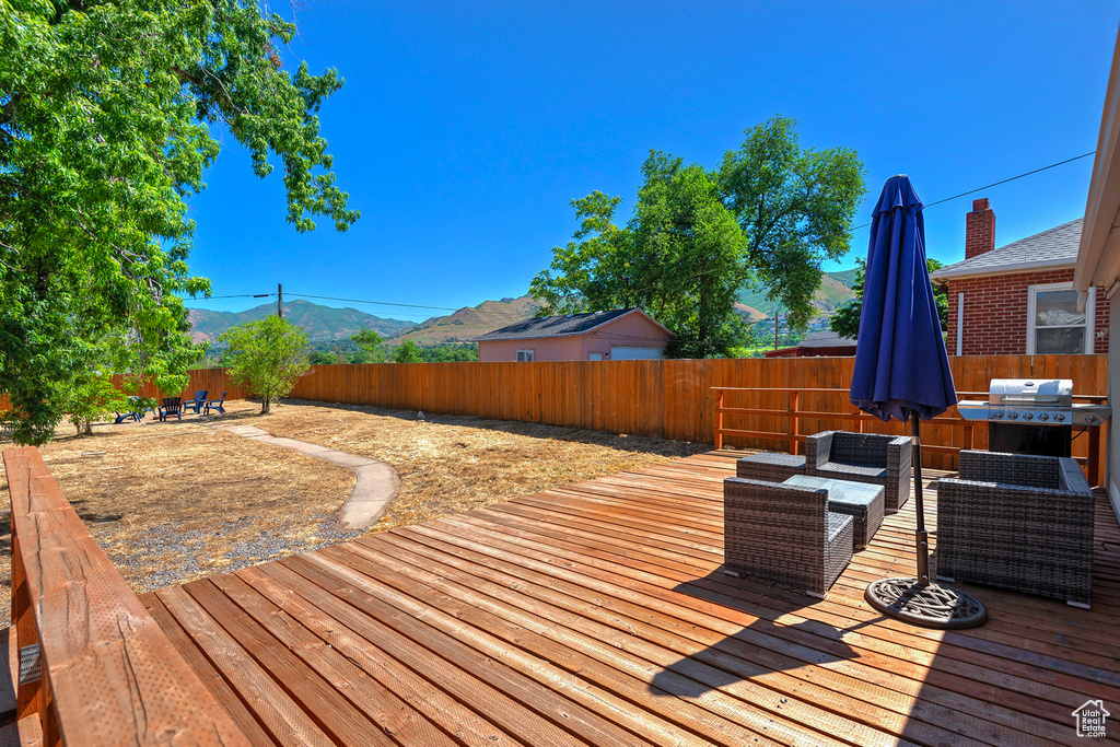 Wooden deck featuring outdoor lounge area, a mountain view, and grilling area