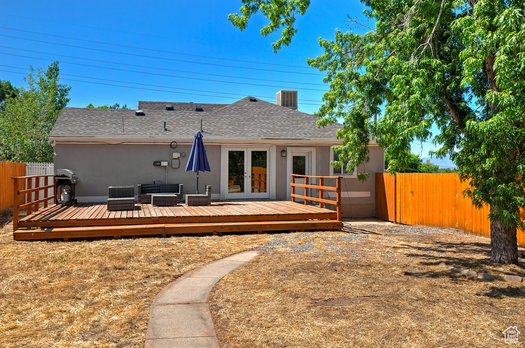 Rear view of property featuring a deck and french doors