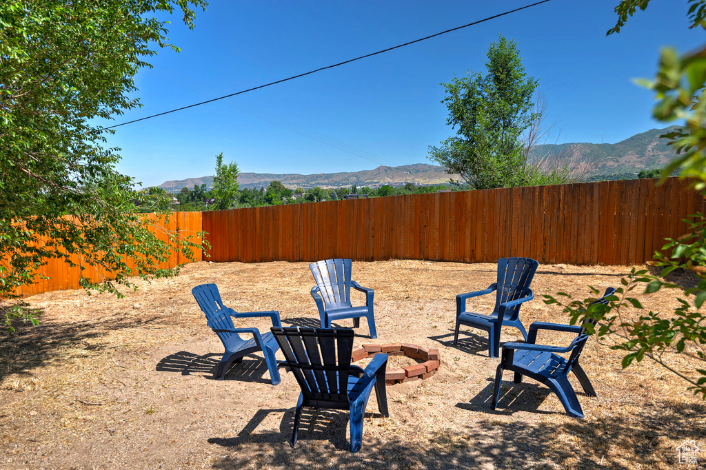 View of yard with an outdoor fire pit and a mountain view