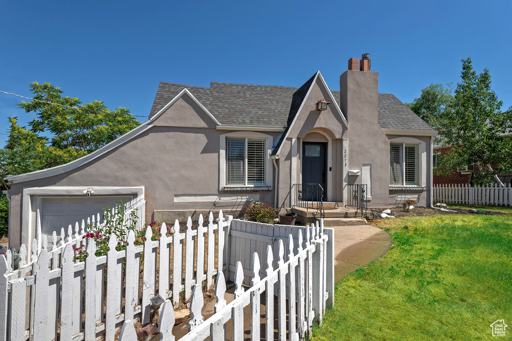 View of front of house with a garage and a front lawn