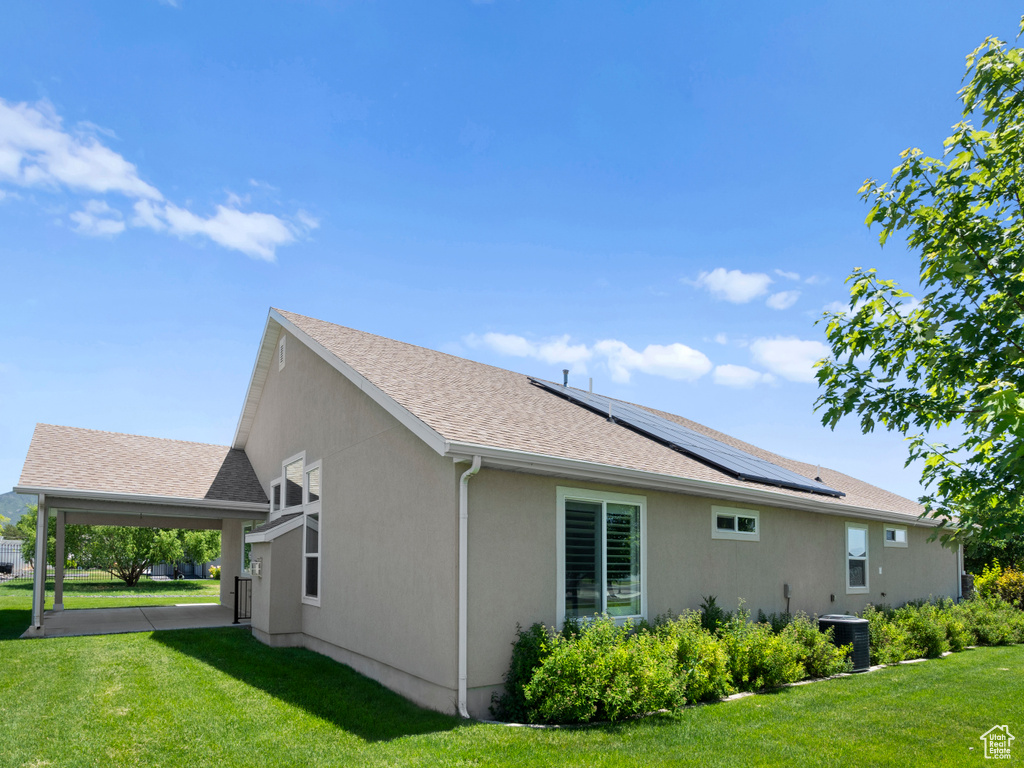 Exterior space featuring a yard, central AC unit, and solar panels