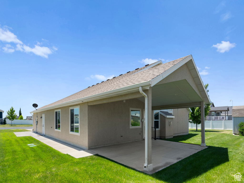 Rear view of property with a patio area and a lawn