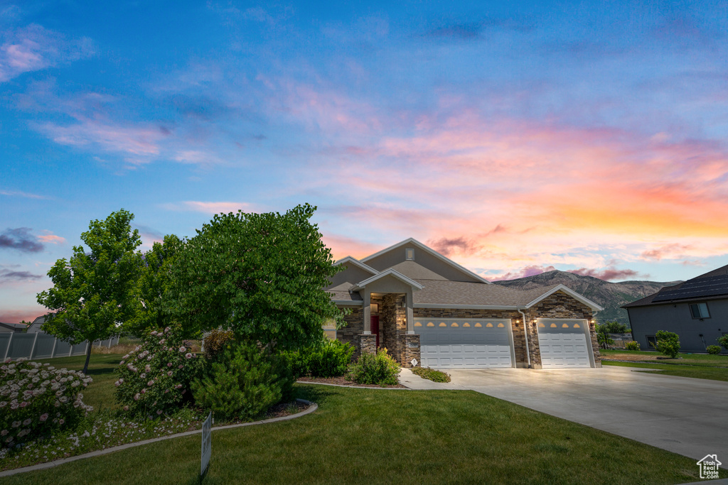 View of front of property with a yard and a garage