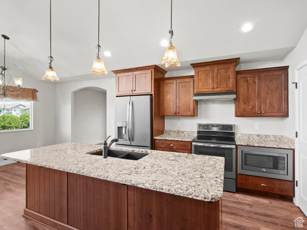 Kitchen with decorative light fixtures, sink, dark hardwood / wood-style floors, and stainless steel appliances