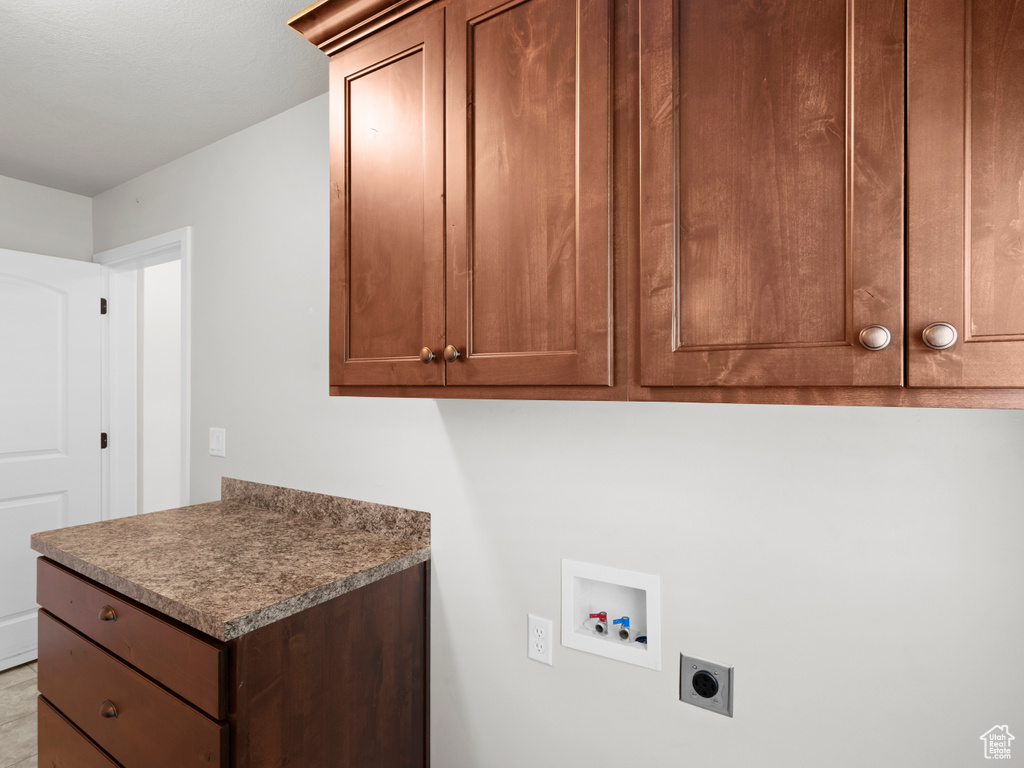 Laundry area with cabinets, hookup for a washing machine, and hookup for an electric dryer