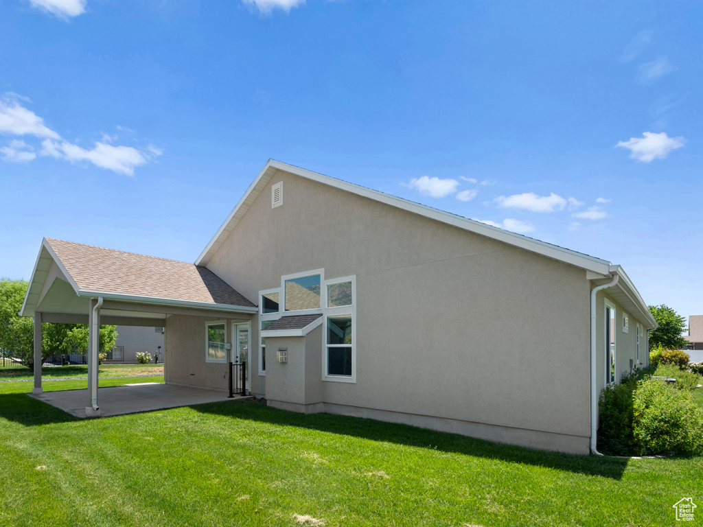 Rear view of house with a patio and a lawn