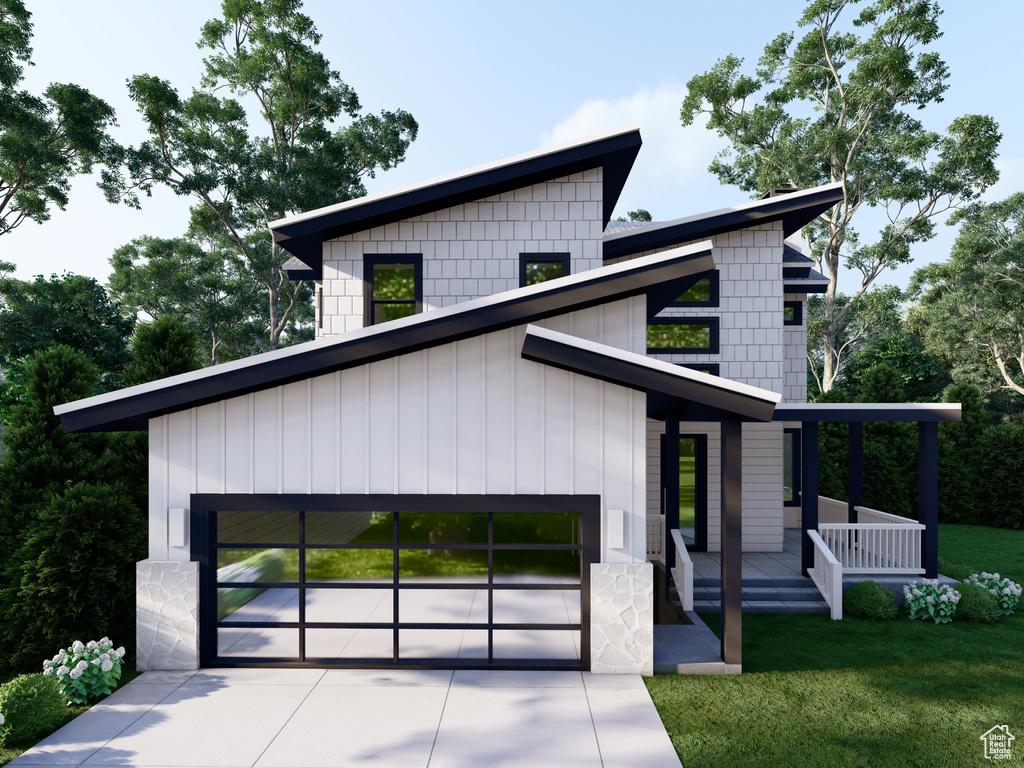 View of front facade featuring a garage and a front lawn