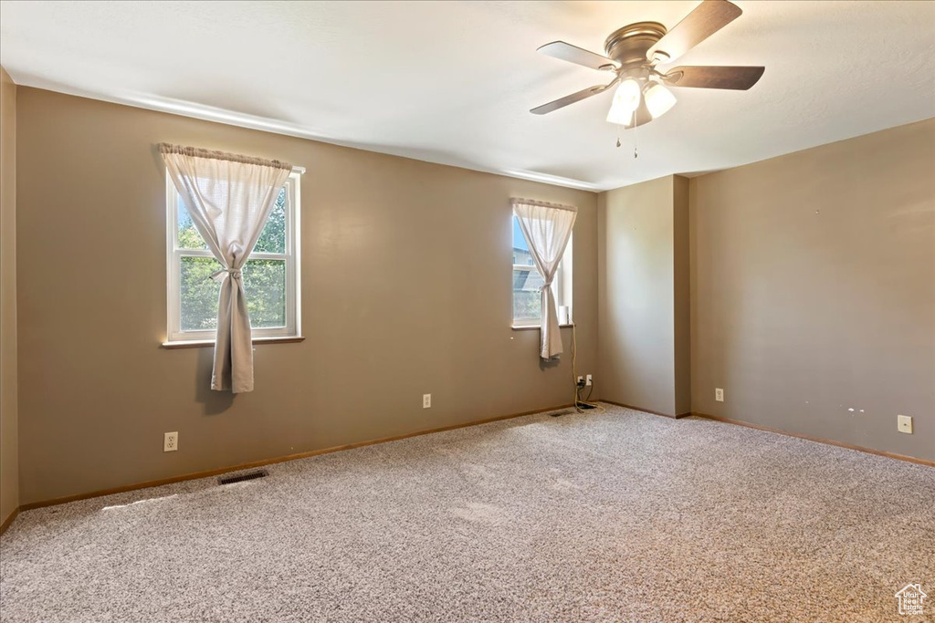 Carpeted spare room with ceiling fan