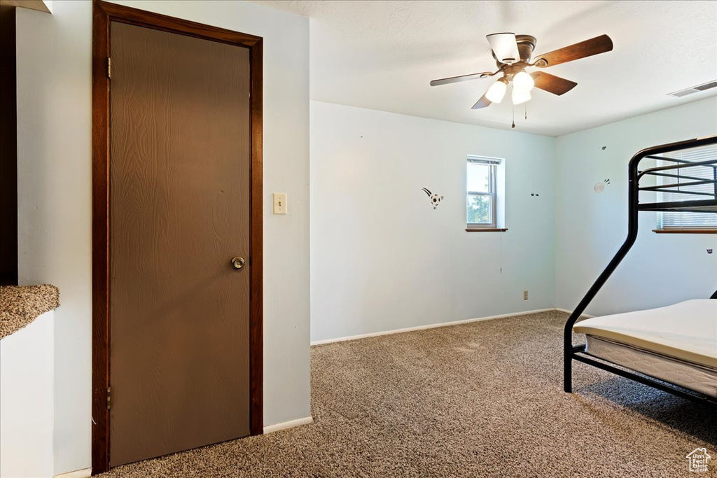 Unfurnished bedroom featuring carpet floors and ceiling fan