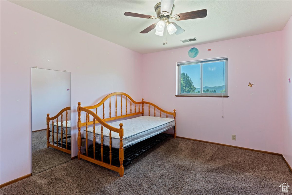 Carpeted bedroom with ceiling fan