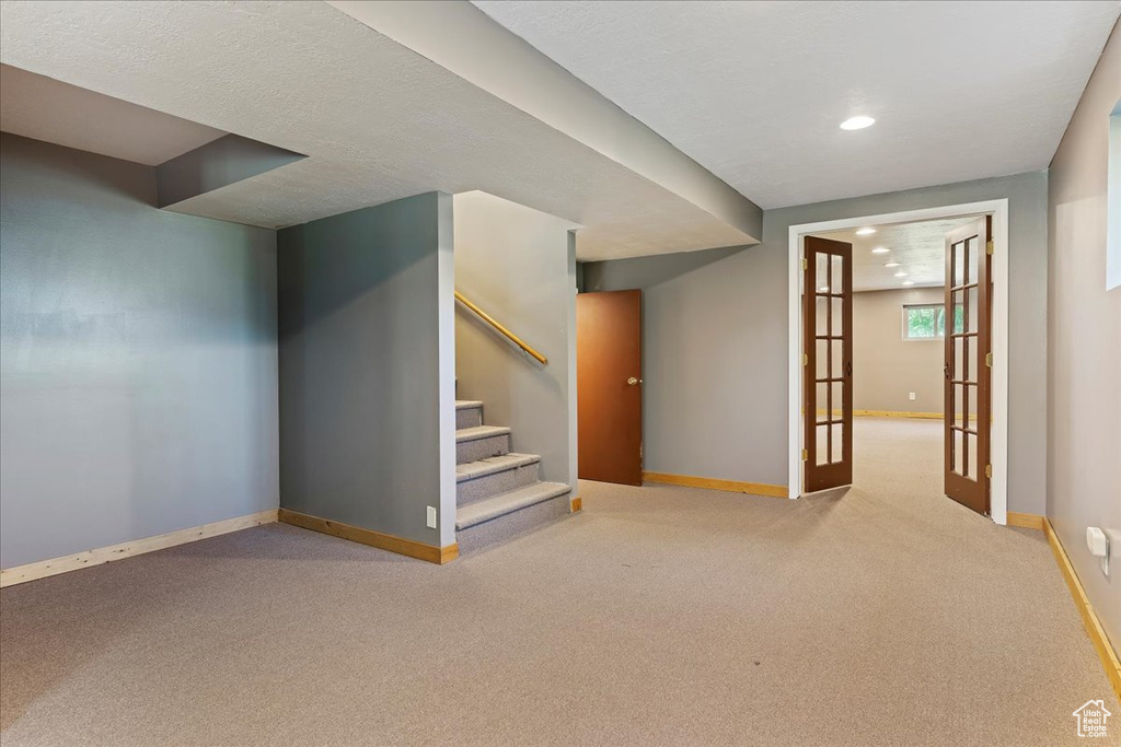 Basement featuring french doors and carpet floors