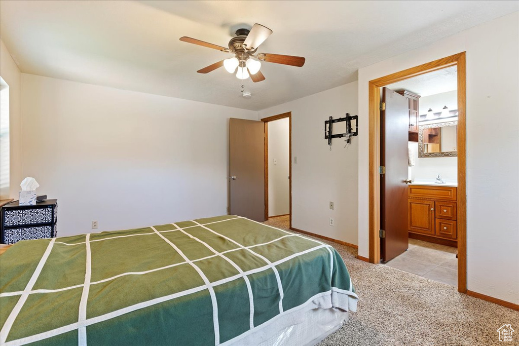 Bedroom with light carpet, ceiling fan, and ensuite bath