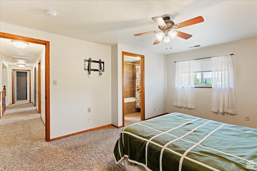 Carpeted bedroom with ceiling fan and connected bathroom