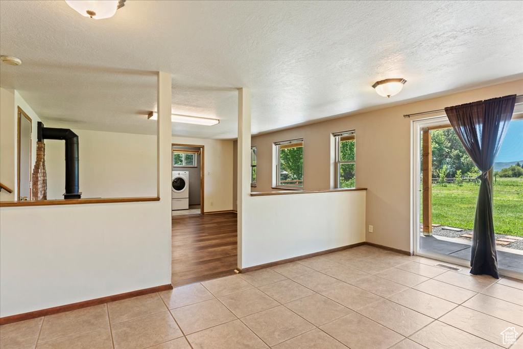 Unfurnished room with a textured ceiling, hardwood / wood-style flooring, and washer / dryer