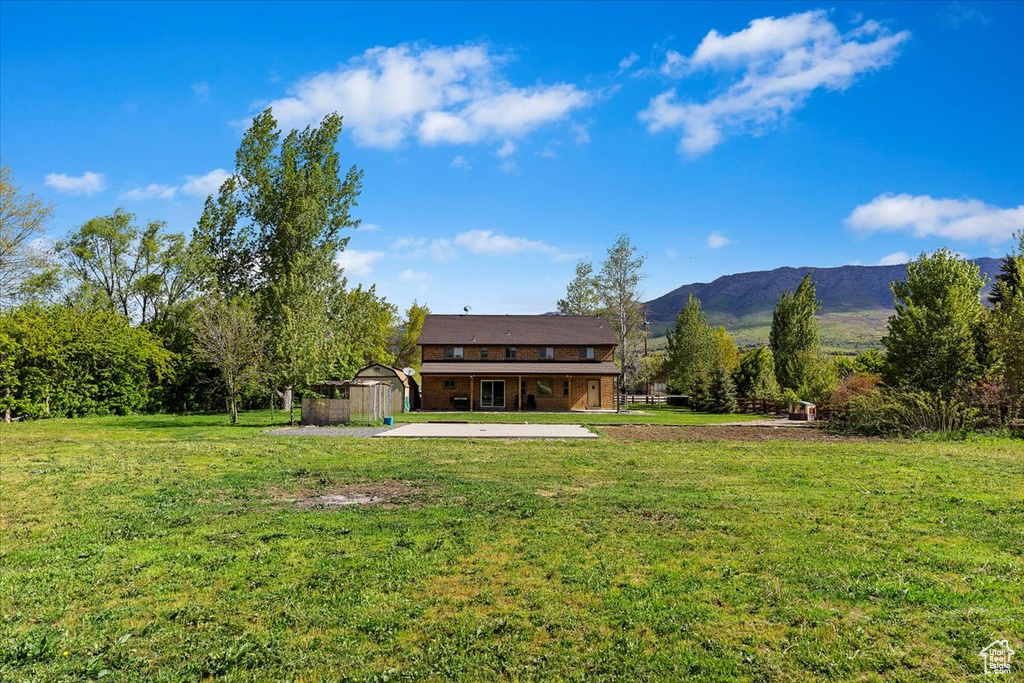 Exterior space featuring a yard, a patio area, and a mountain view