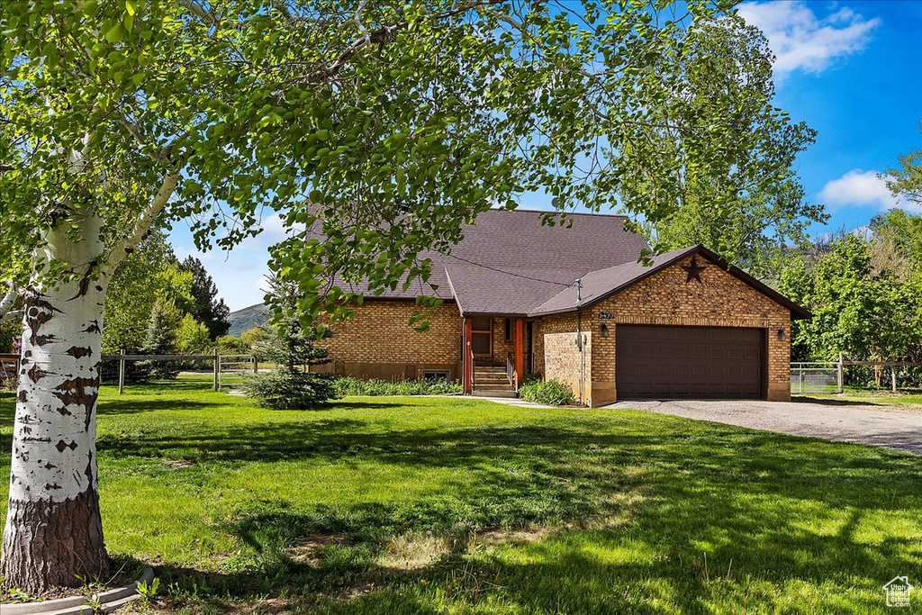 View of front of home featuring a garage and a front lawn