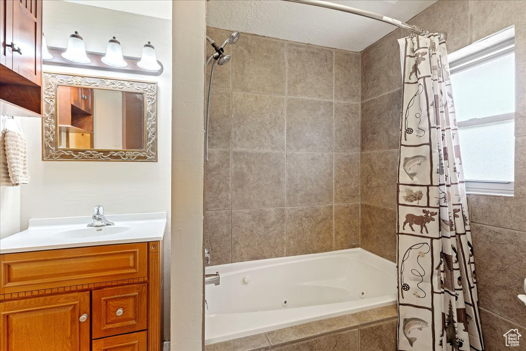 Bathroom with shower / bath combination with curtain and vanity