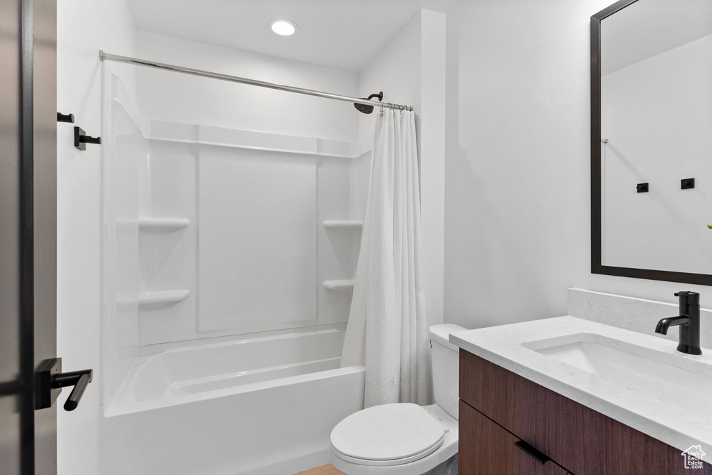 Full bathroom featuring shower / bathtub combination with curtain, large vanity, and toilet