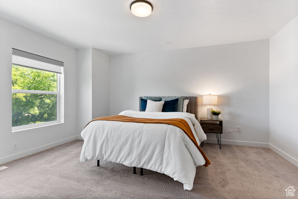 Bedroom featuring light colored carpet