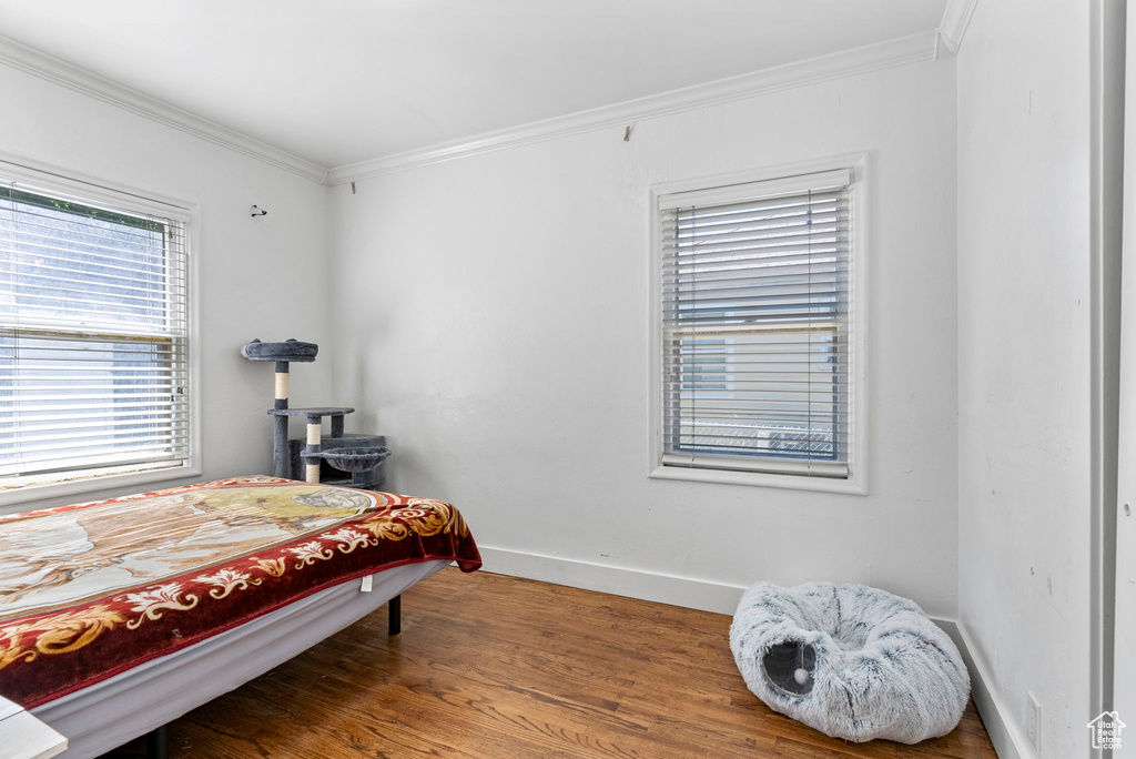 Bedroom featuring ornamental molding and wood-type flooring