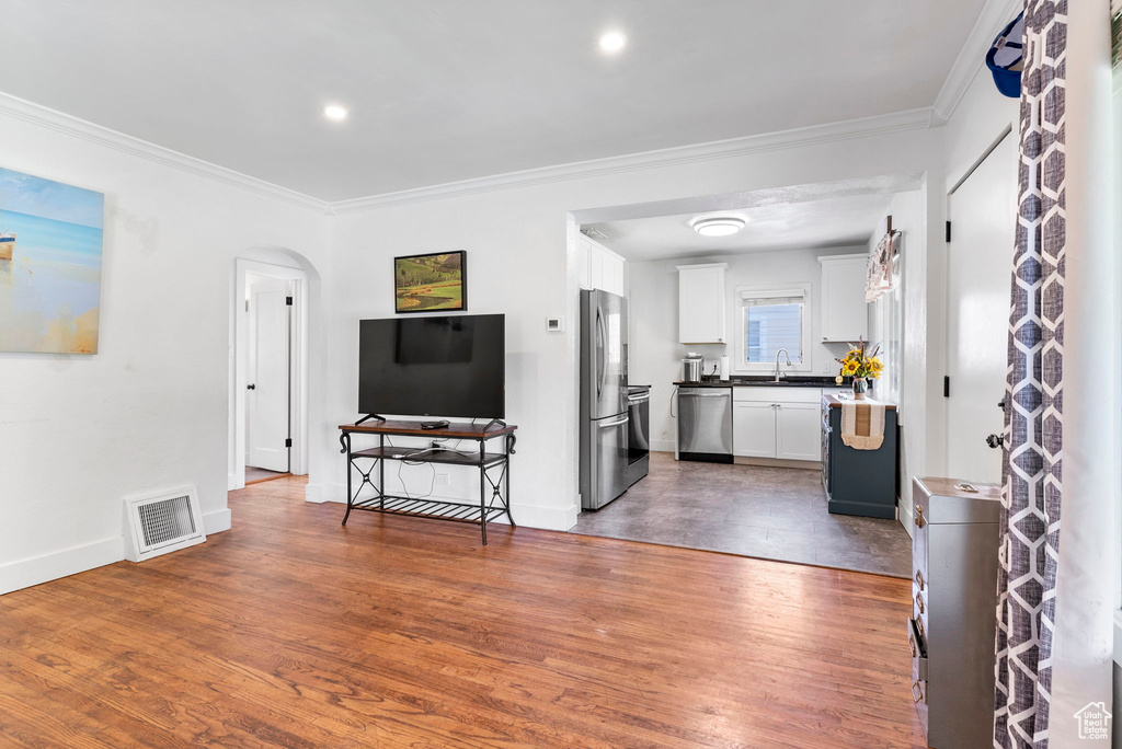 Living room with sink, ornamental molding, and dark hardwood / wood-style floors