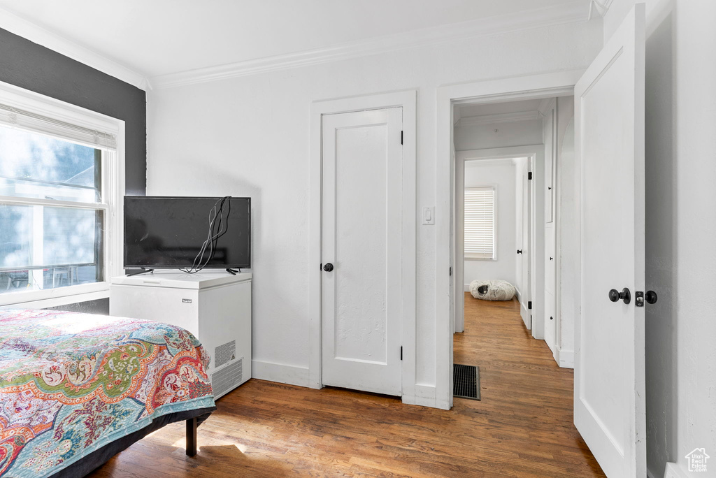 Bedroom featuring ornamental molding and hardwood / wood-style floors