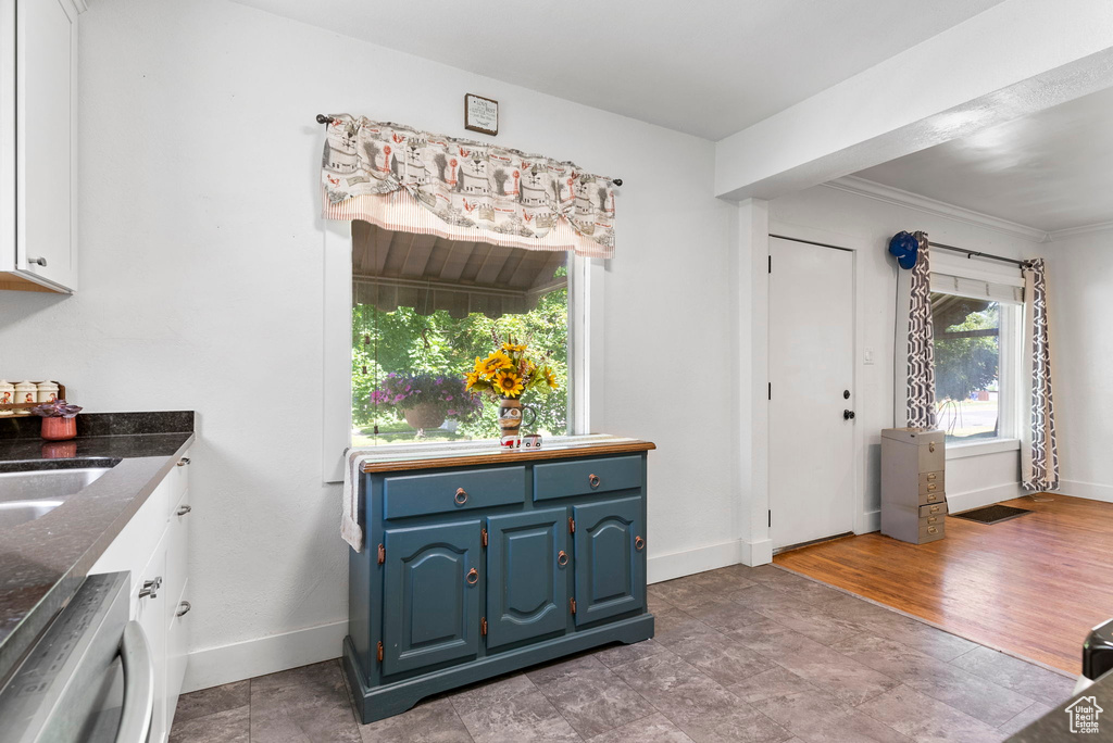 Interior space featuring a healthy amount of sunlight, ornamental molding, and wood-type flooring