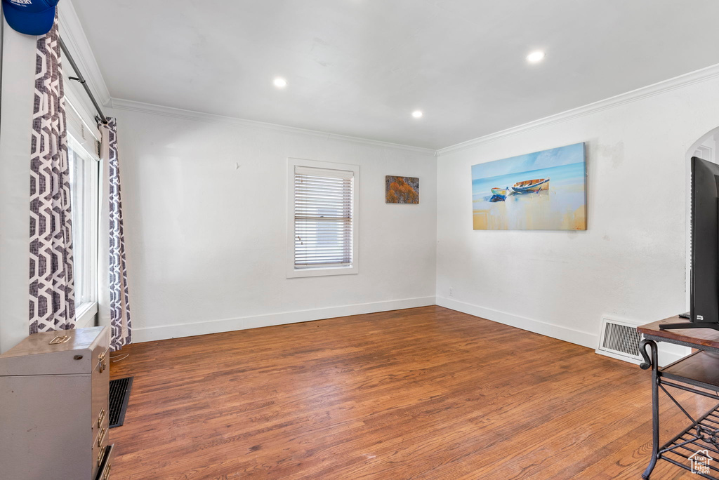 Living room with ornamental molding and wood-type flooring