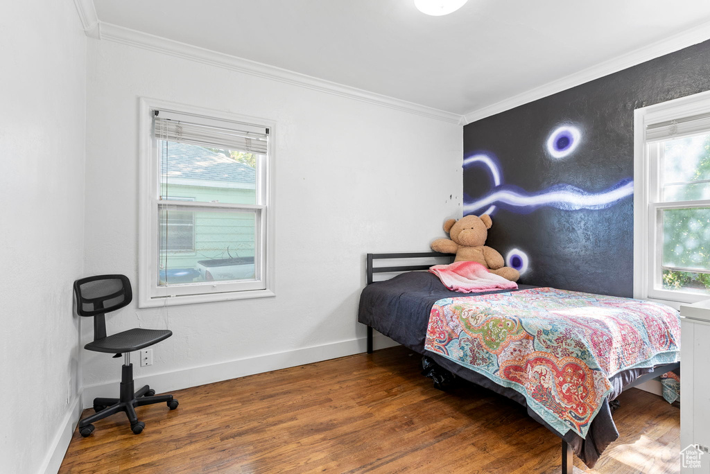 Bedroom featuring crown molding and dark hardwood / wood-style flooring