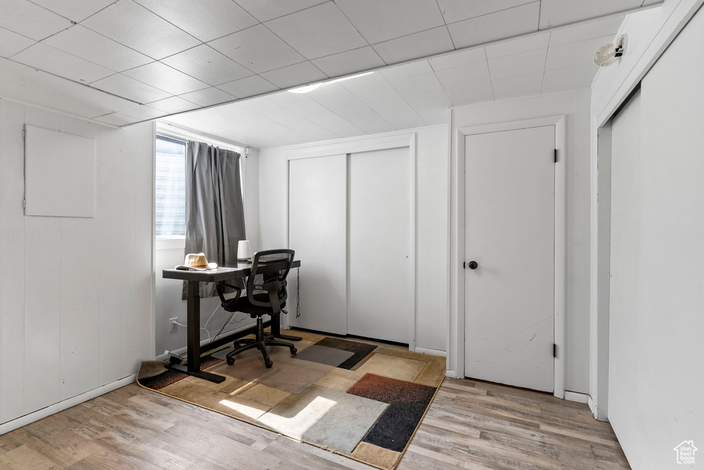 Office space with light wood-type flooring and a drop ceiling