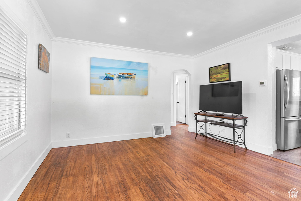 Living room featuring ornamental molding and wood-type flooring