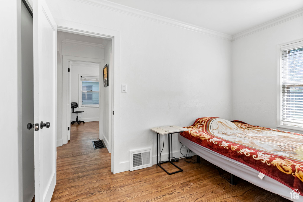 Bedroom featuring crown molding and hardwood / wood-style floors