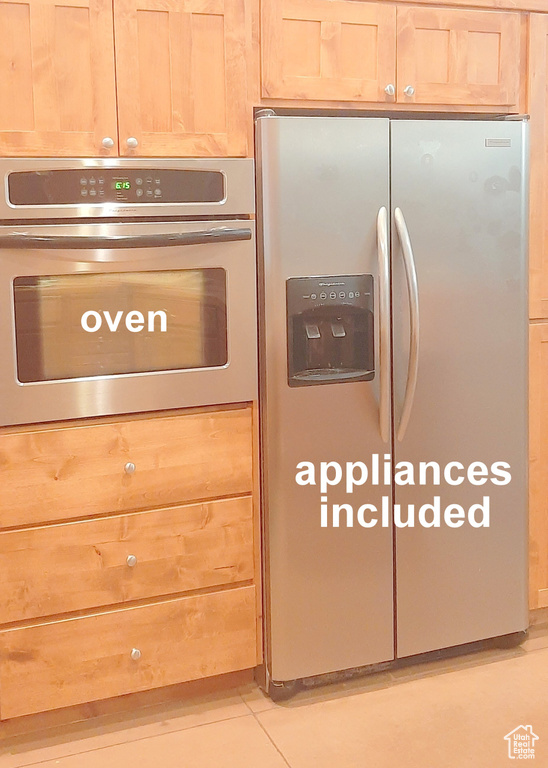 Interior space with light brown cabinetry, appliances with stainless steel finishes, and light tile patterned floors