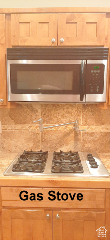 Kitchen with light brown cabinets and backsplash