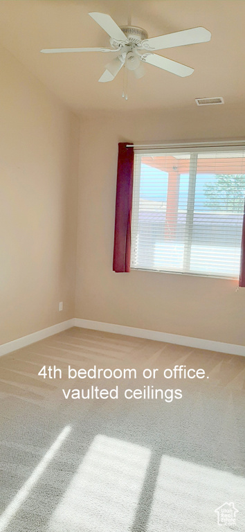 Spare room featuring carpet, ceiling fan, and a wealth of natural light