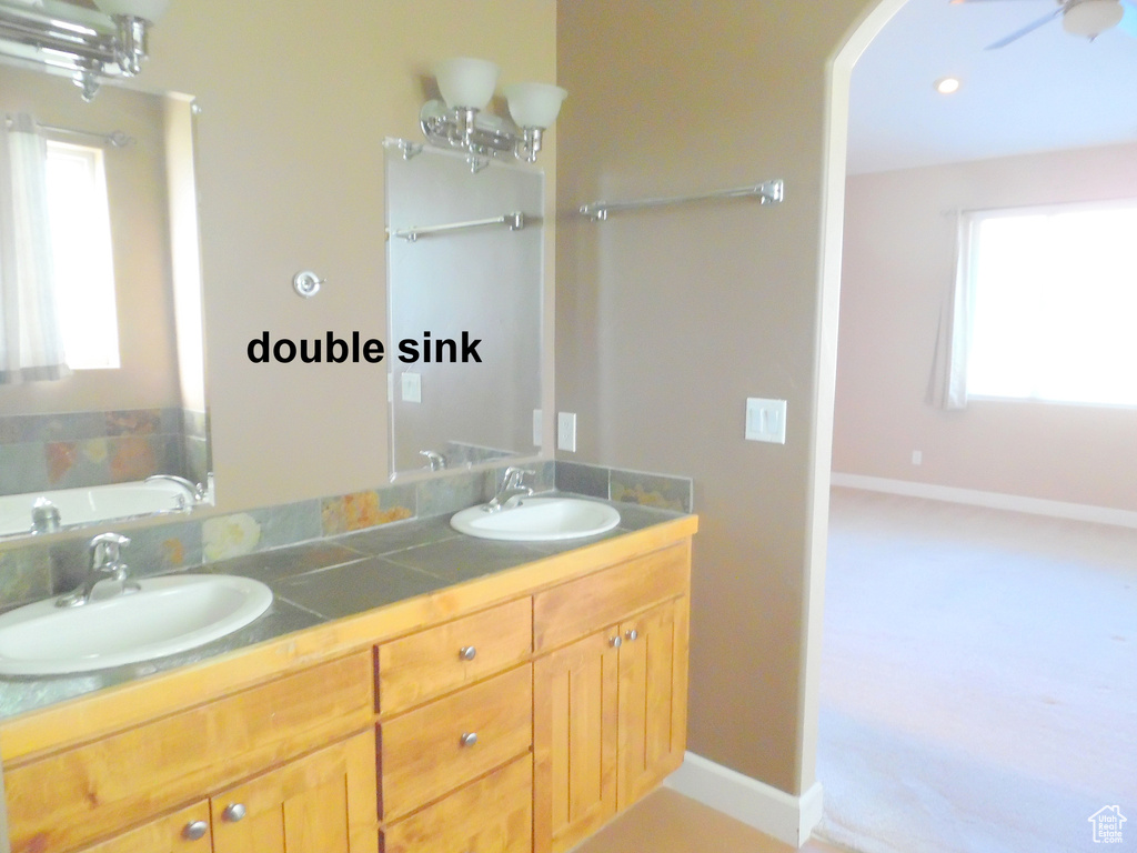 Bathroom featuring a tub to relax in and double sink vanity