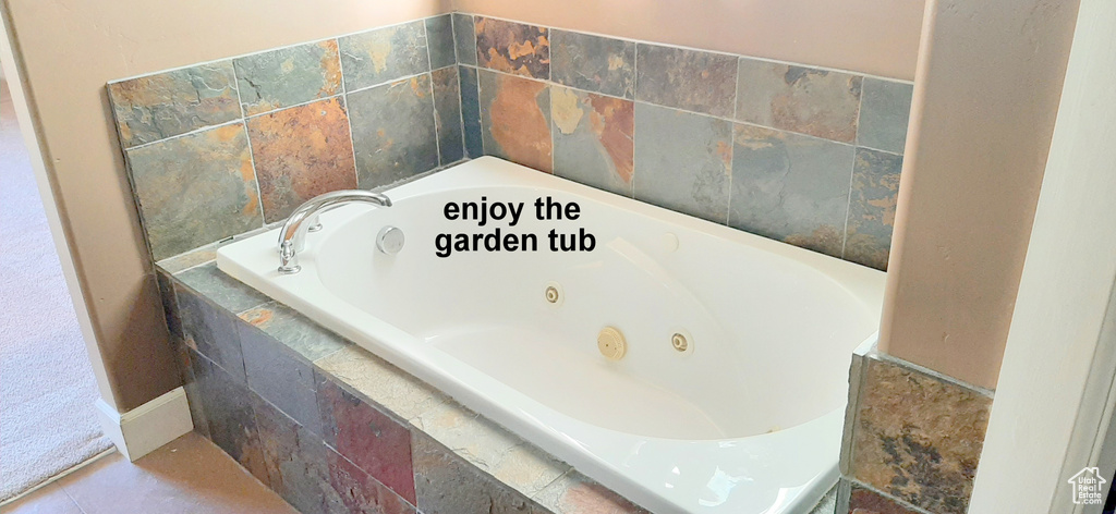 Bathroom featuring tile patterned flooring and tiled bath