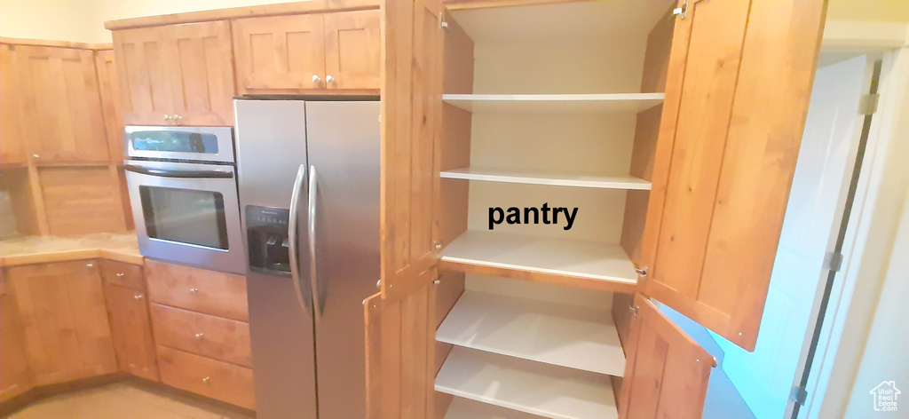 Kitchen with light brown cabinetry and stainless steel appliances