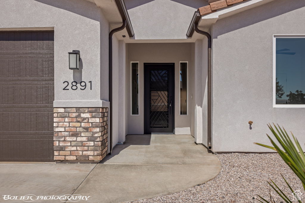 View of exterior entry with a garage