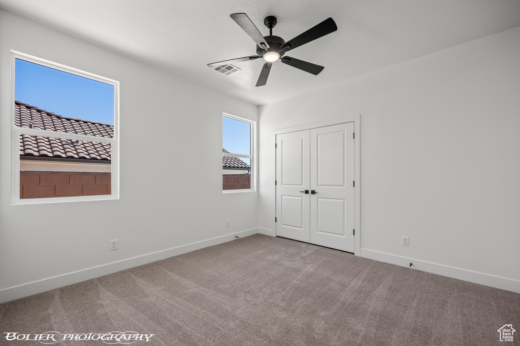 Unfurnished room with ceiling fan and carpet floors