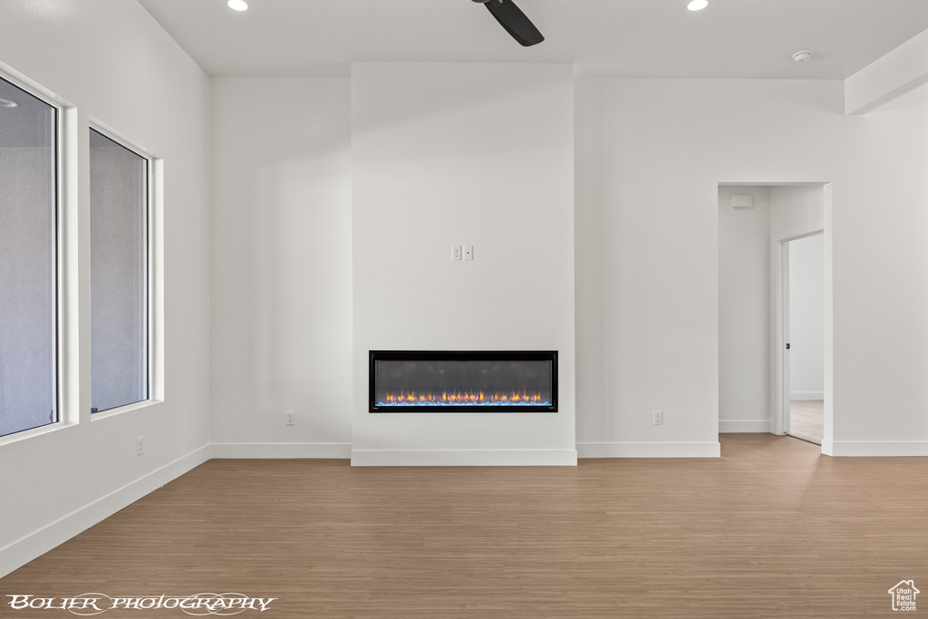 Unfurnished living room featuring light wood-type flooring and ceiling fan